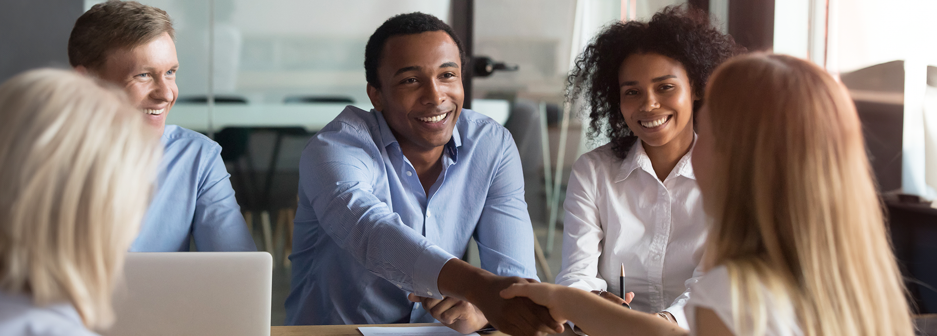 businesspeople shaking hands across table