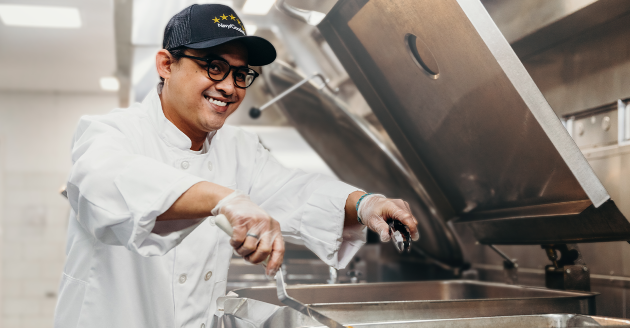 man at deep fryer smiling
