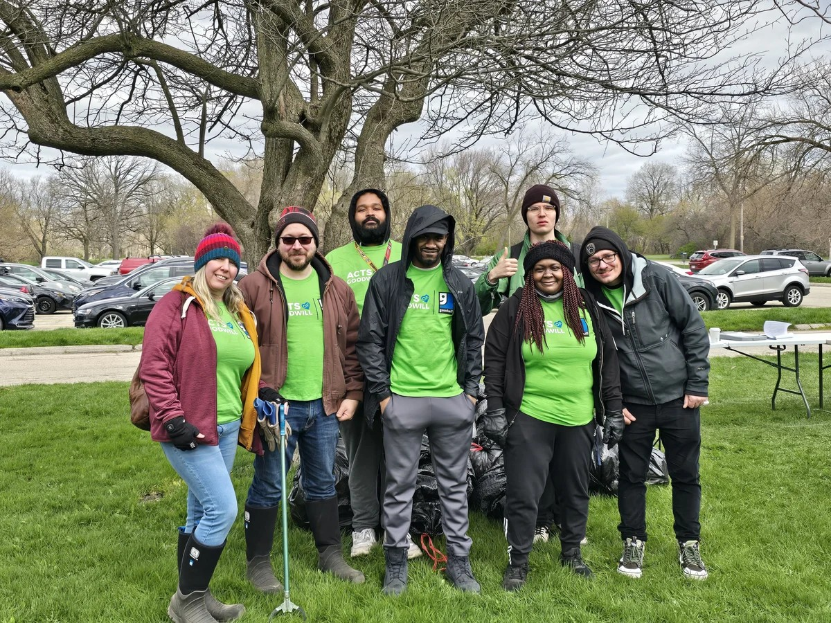 Goodwill volunteers in front of a tree