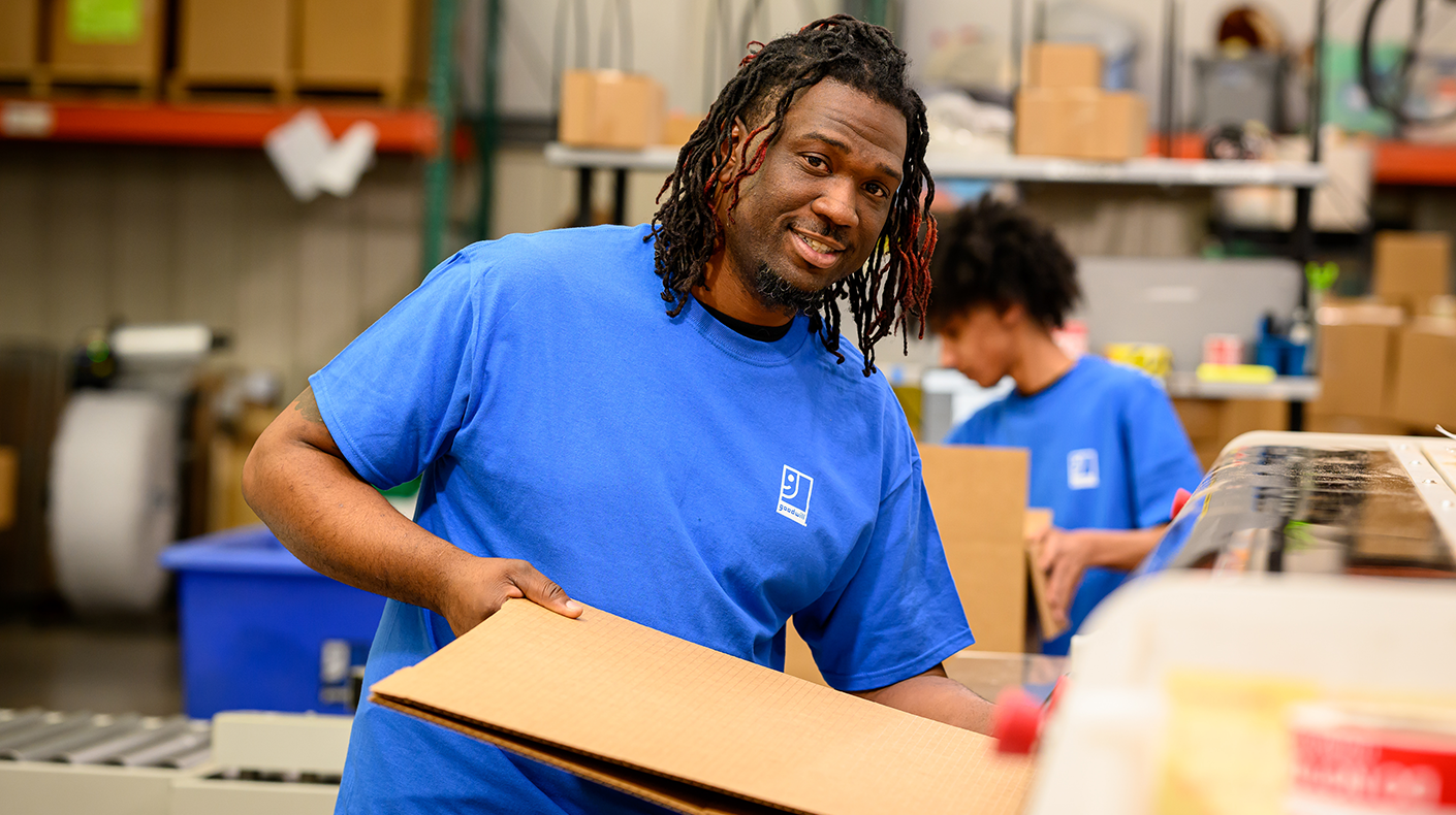 employee holding flattened cardboard box