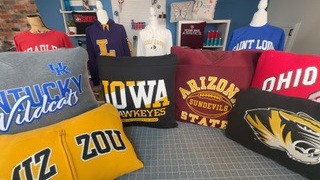 A variety of decorative pillows with college logos on them