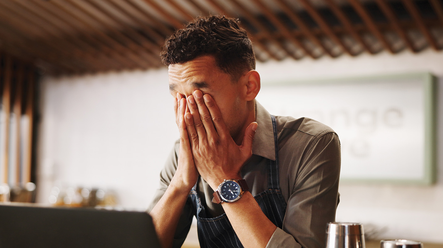 Stressed employee with head in hands