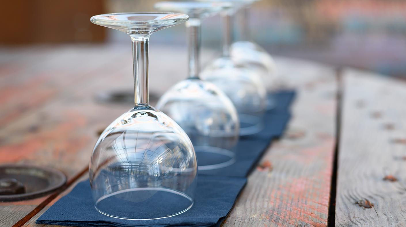 Wine glasses upside down resting on black napkins