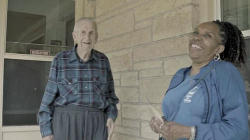 meals on wheels recipient and delivery driver laughing
