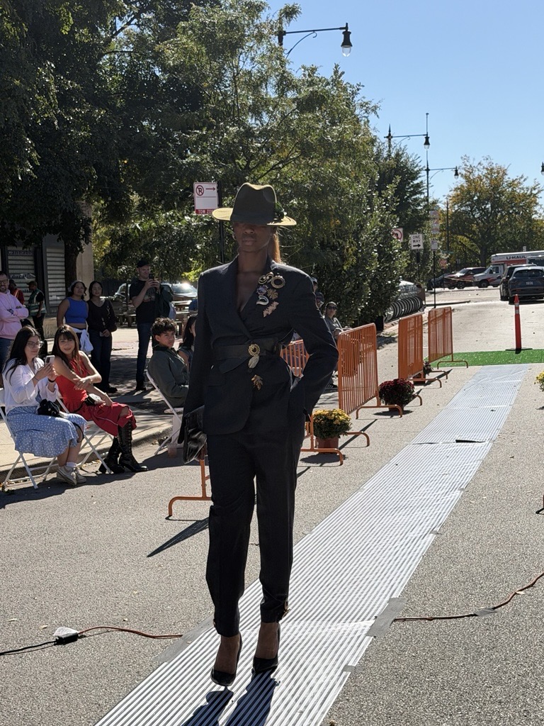 Model on the runway wearing an upcycled suit and fedora