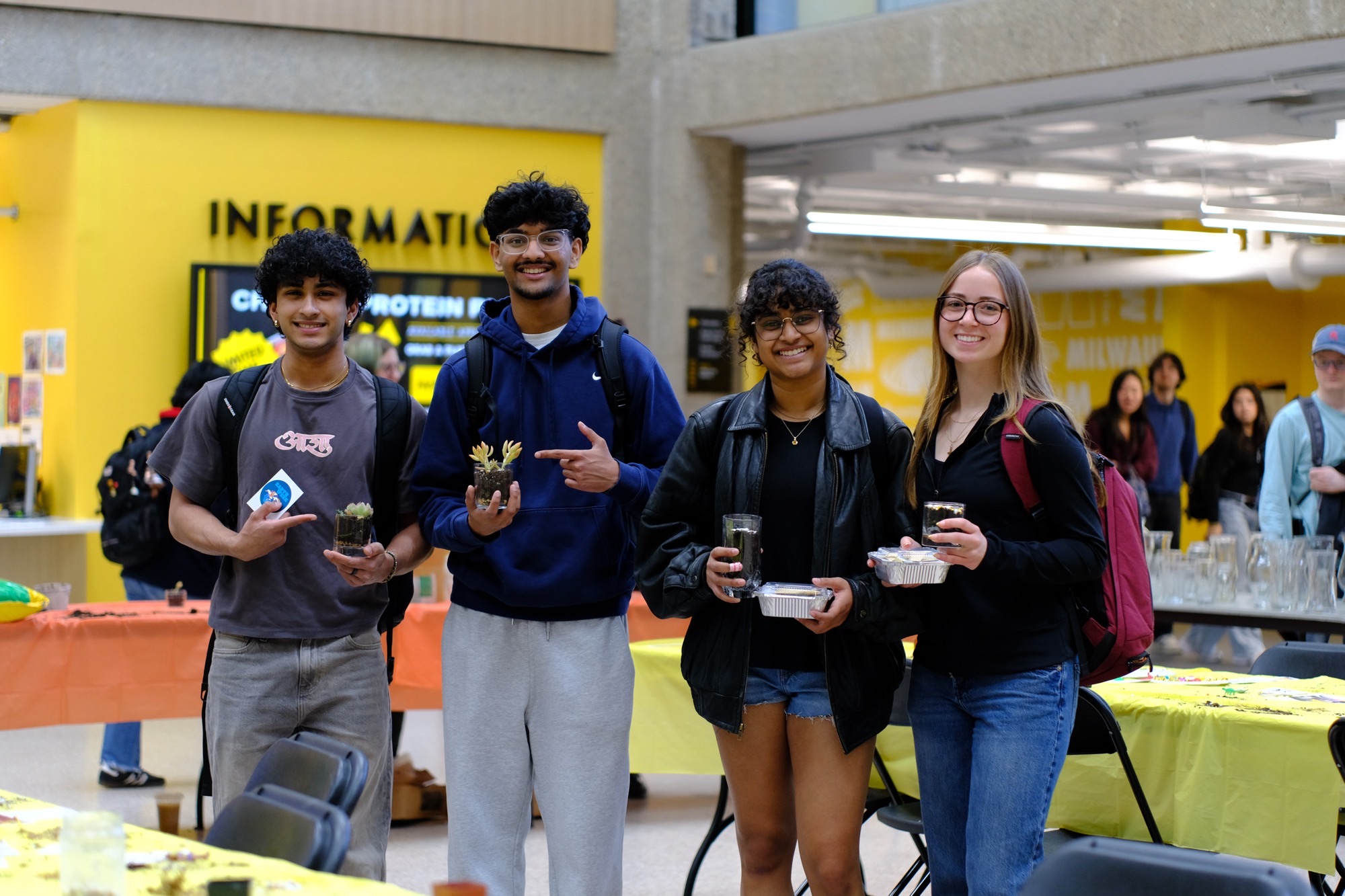 UWM students showing off their DIY terrariums Young adults smiling and holding their DIY terrariums