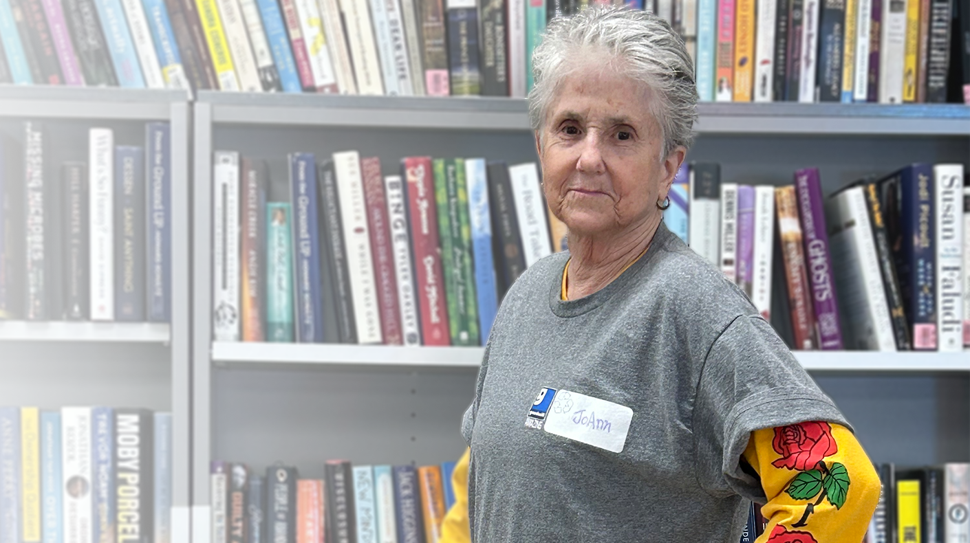 goodwill store employee in front of books