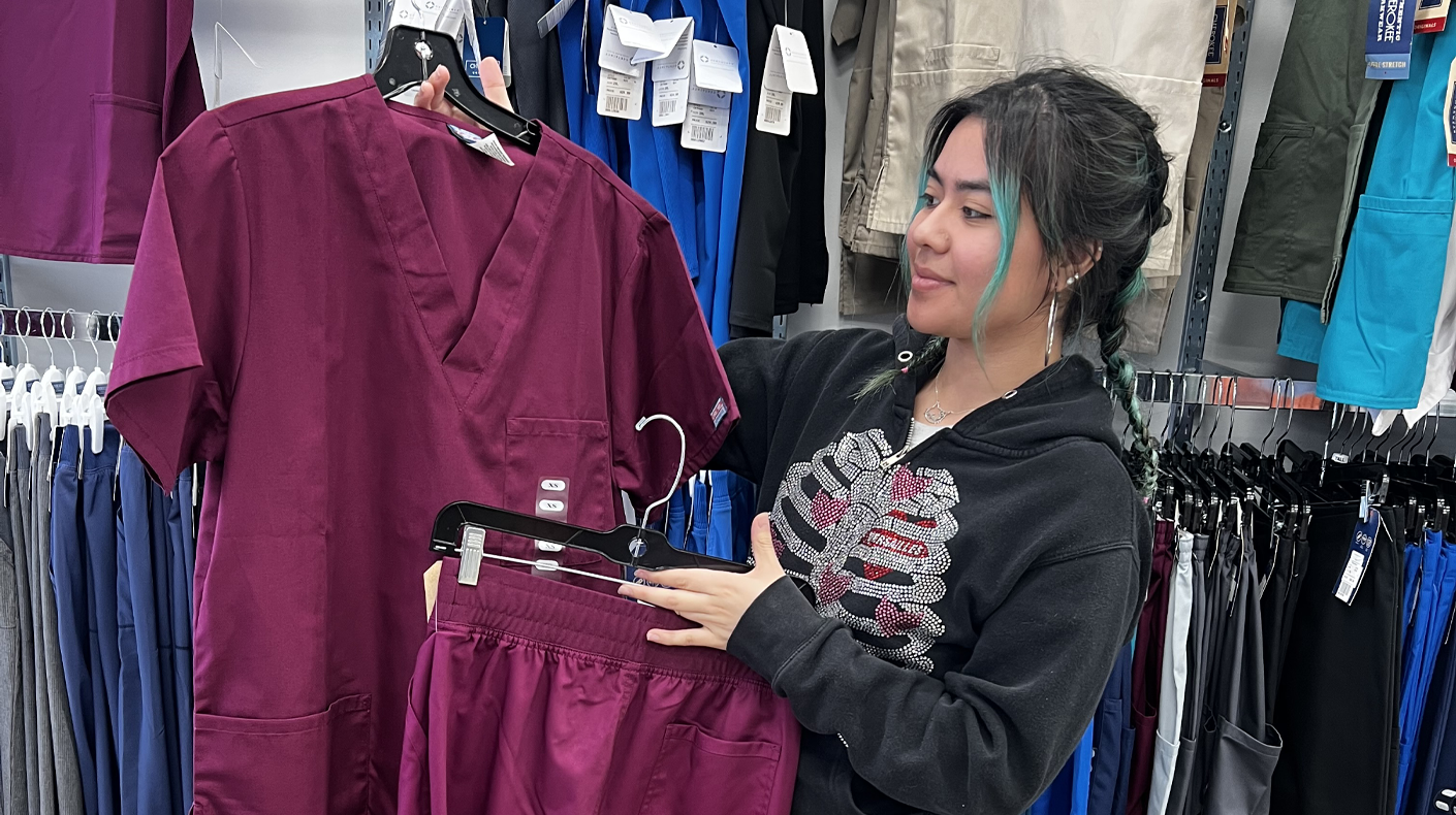Woman holding CNA scrubs