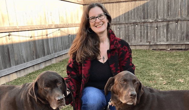 woman outside with two brown dogs