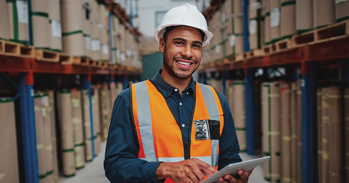 man wearing safety vest and hard hat in warehouse