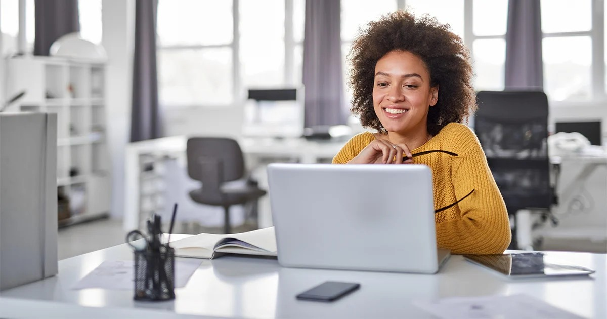woman holding glasses in front of laptop