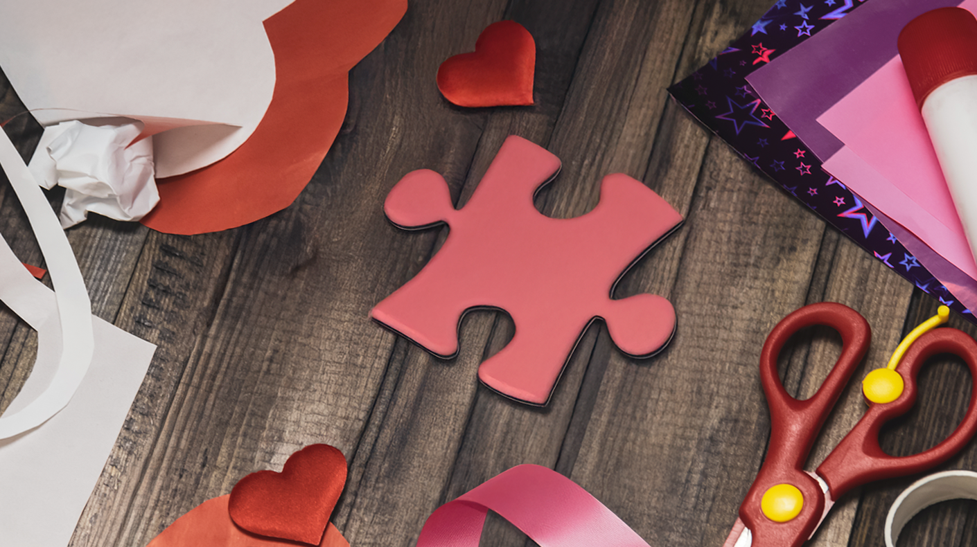 A red puzzle piece among Valentine's Day style crafts
