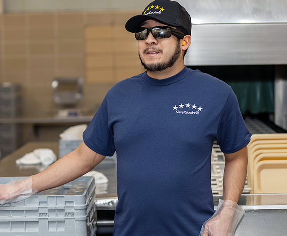 Visually impaired employee of Goodwill Great Lakes in a blue shirt, black hat and sunglasses