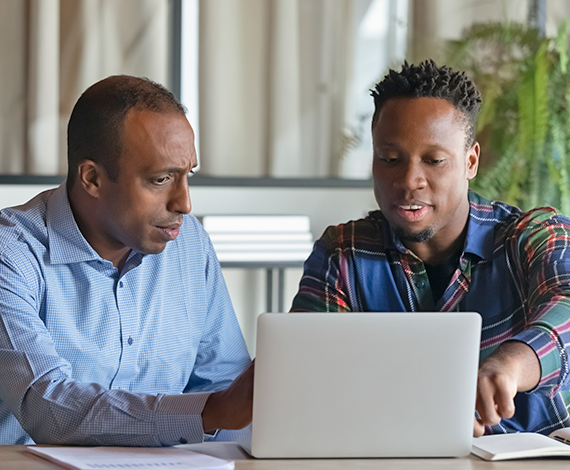 two men in front of a laptop workforce connection center help
